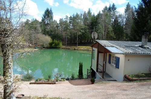 Augignac Ski Chalet | Chalet overlooking a pond in a green setting.